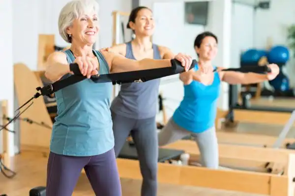 older woman doing weight training Camberley and resistance in the gym to tone upper arms